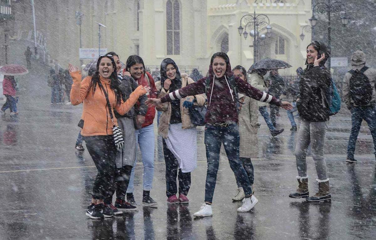 People enjoy snowfall at the Ridge, in Shimla, Wednesday, Dec 12, 2018. (PTI Photo)