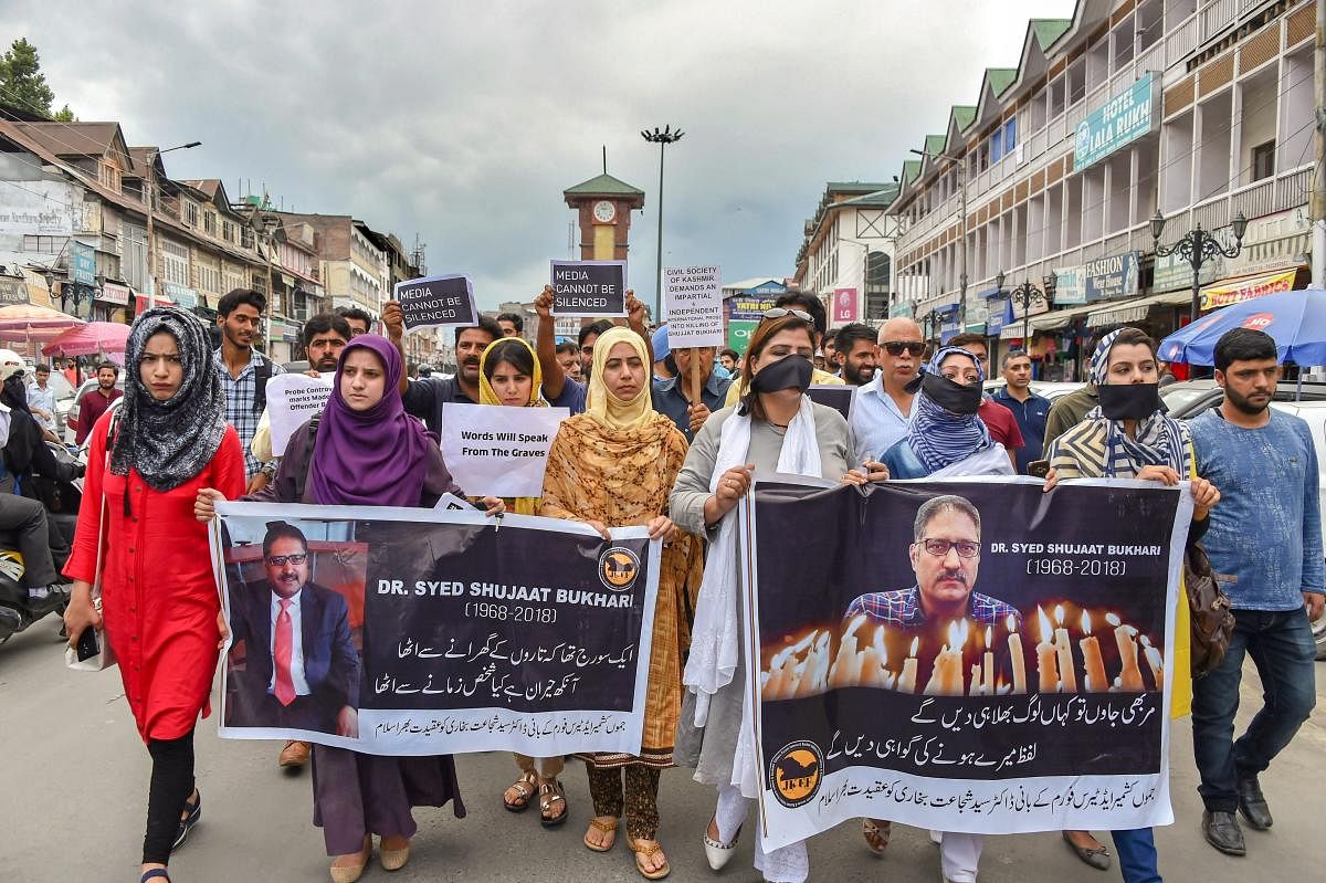 Journalists hold placards during a silent protest march against the killing of Rising Kashmir newspaper editor-in-chief Shujaat Bukhari, in Srinagar on June 26.