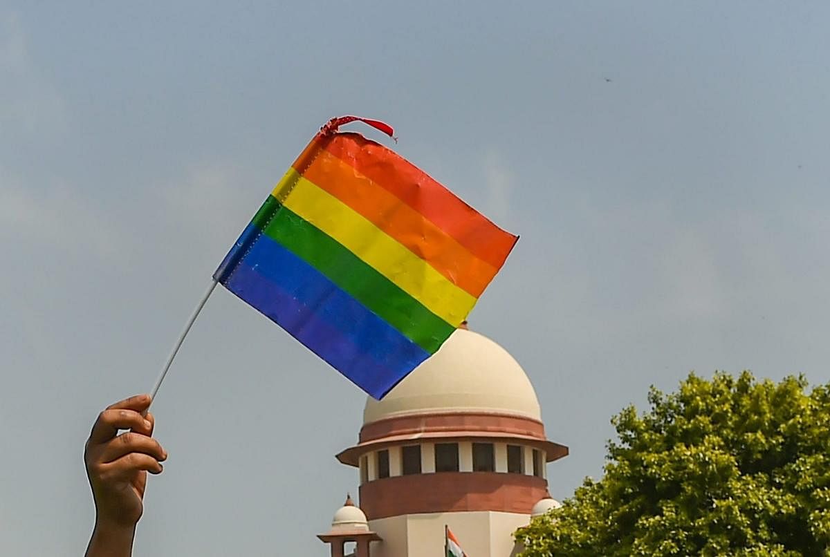 An activist waves a rainbow flag after the Supreme Court verdict decriminalised consensual gay sex, outside the Supreme Court in New Delhi on September 6. A five-judge constitution bench of the Supreme Court unanimously decriminalised part of the 158-year-old colonial law under Section 377 of the IPC which criminalises consensual unnatural sex, saying it violated the rights to equality.