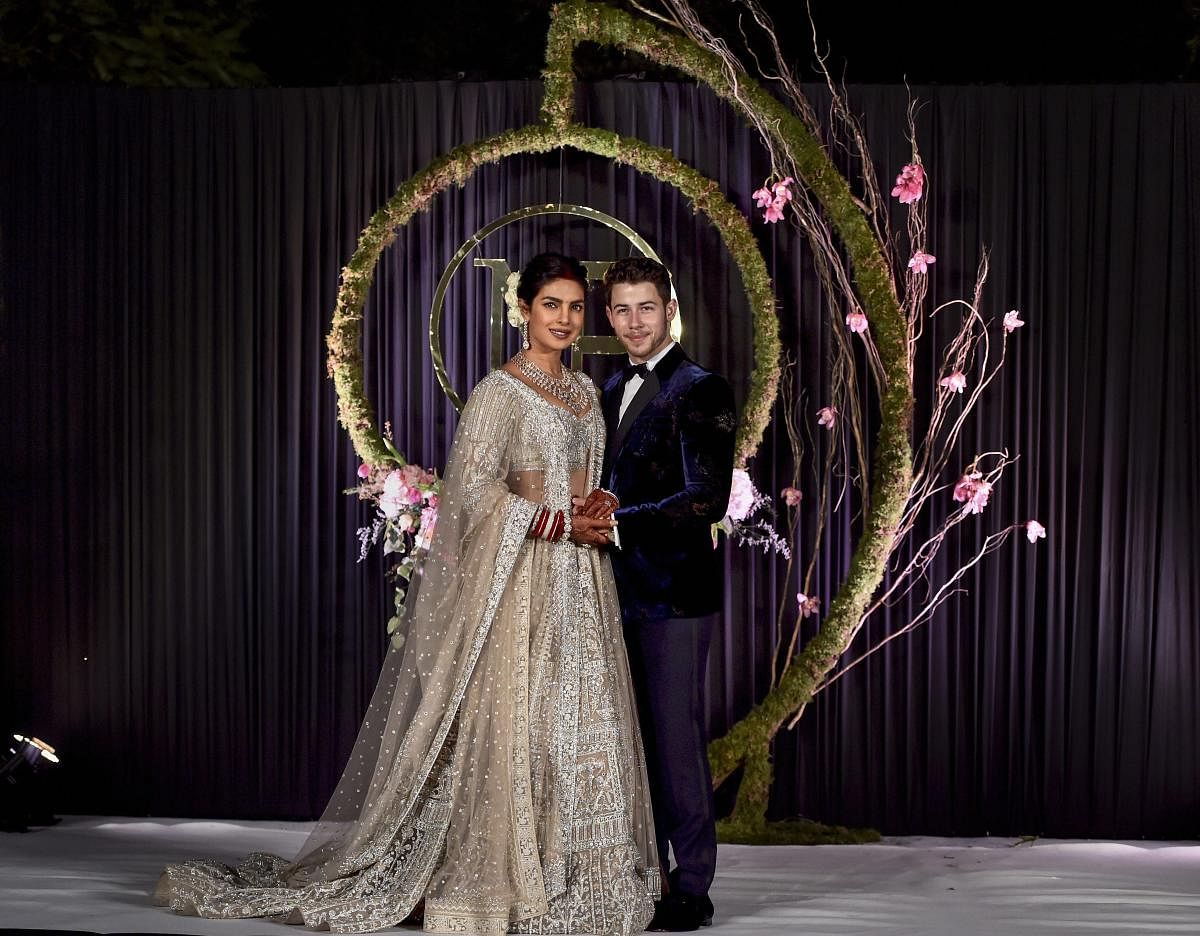 Newly-wed Bollywood actor Priyanka Chopra and American singer Nick Jonas pose for photos during their wedding reception, in New Delhi, on December 4.