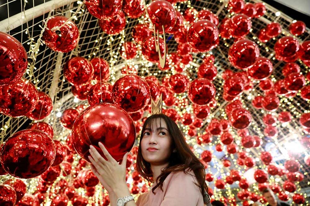 A woman poses for a photo with Christmas ornaments as she celebrates Christmas in Bangkok, Thailand. Reuters Photo