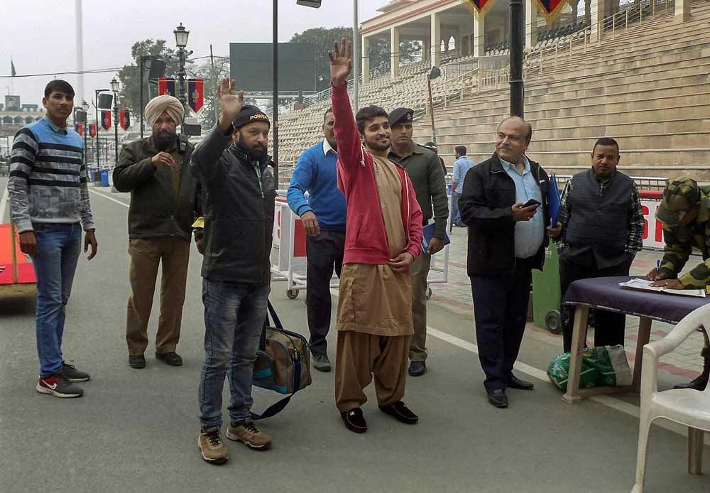 Released Pakistani prisoners Abdullah Khan and Mohammad Imran Qureshi Warsi wave as they leave for their country through Wagah border, about 35 km from Amritsar, Wednesday, December 26, 2018. They were released by the Indian authorities as a goodwill gesture. PTI Photo