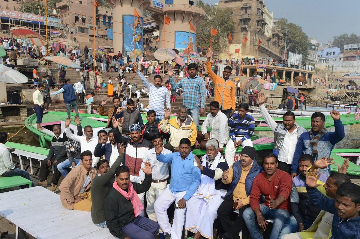 Boatmen raise slogans during a protest against the newly-inaugurated cruise services which they claimed hampers their livelihood, at Rajendra Prasad Ghat, in Varanasi. PTI