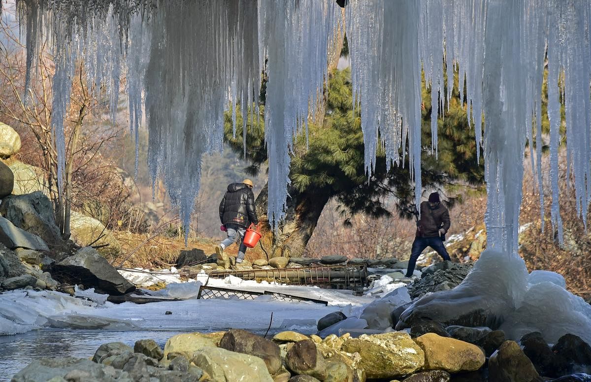 Men cross a stream as huge icicles hang from a bridge at Tangmarg in district Baramulla of north Kashmir, Sunday, December 30, 2018. The residents in Kashmir experienced huge relief from the intense cold wave conditions as the mercury improved by several degrees across the valley and Ladakh region last night, even as the minimum temperature continued to settle below the freezing point. PTI