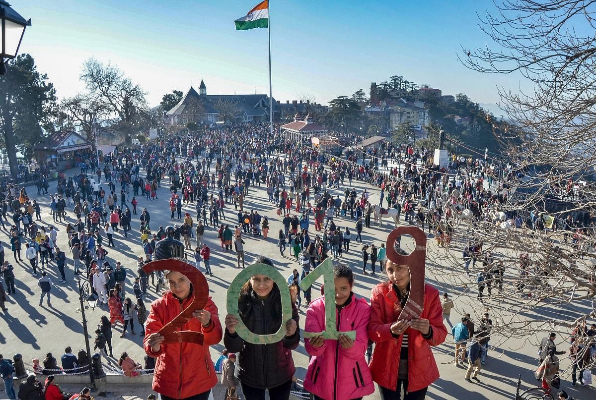 Youngsters hold cutouts that read '2019', on the New Year's eve, at Ridge in Shimla. PTI
