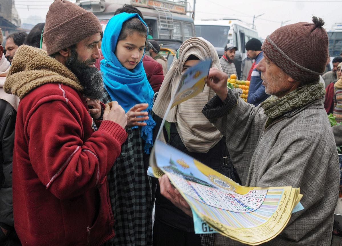 People buy calendars on the first day of the new year 2019, at a market in Srinagar. PTI