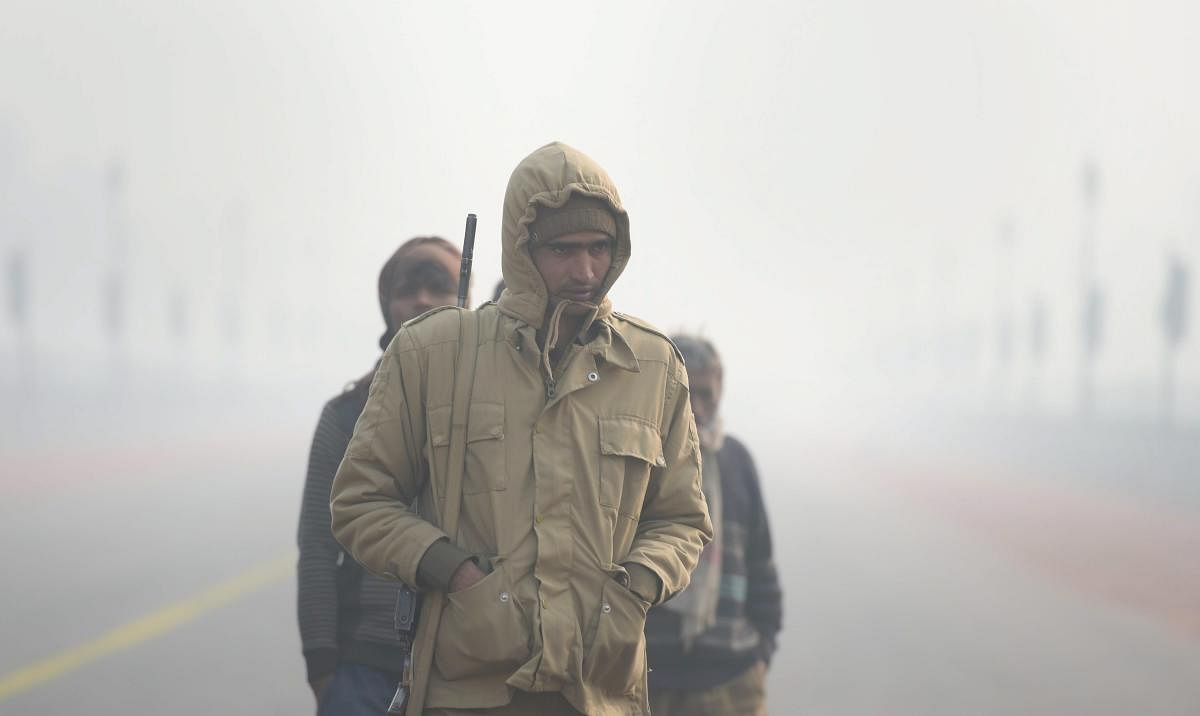 A policeman stands guard during Republic Day parade rehersals, at Rajpath, on a cold, foggy morning, in New Delhi. PTI