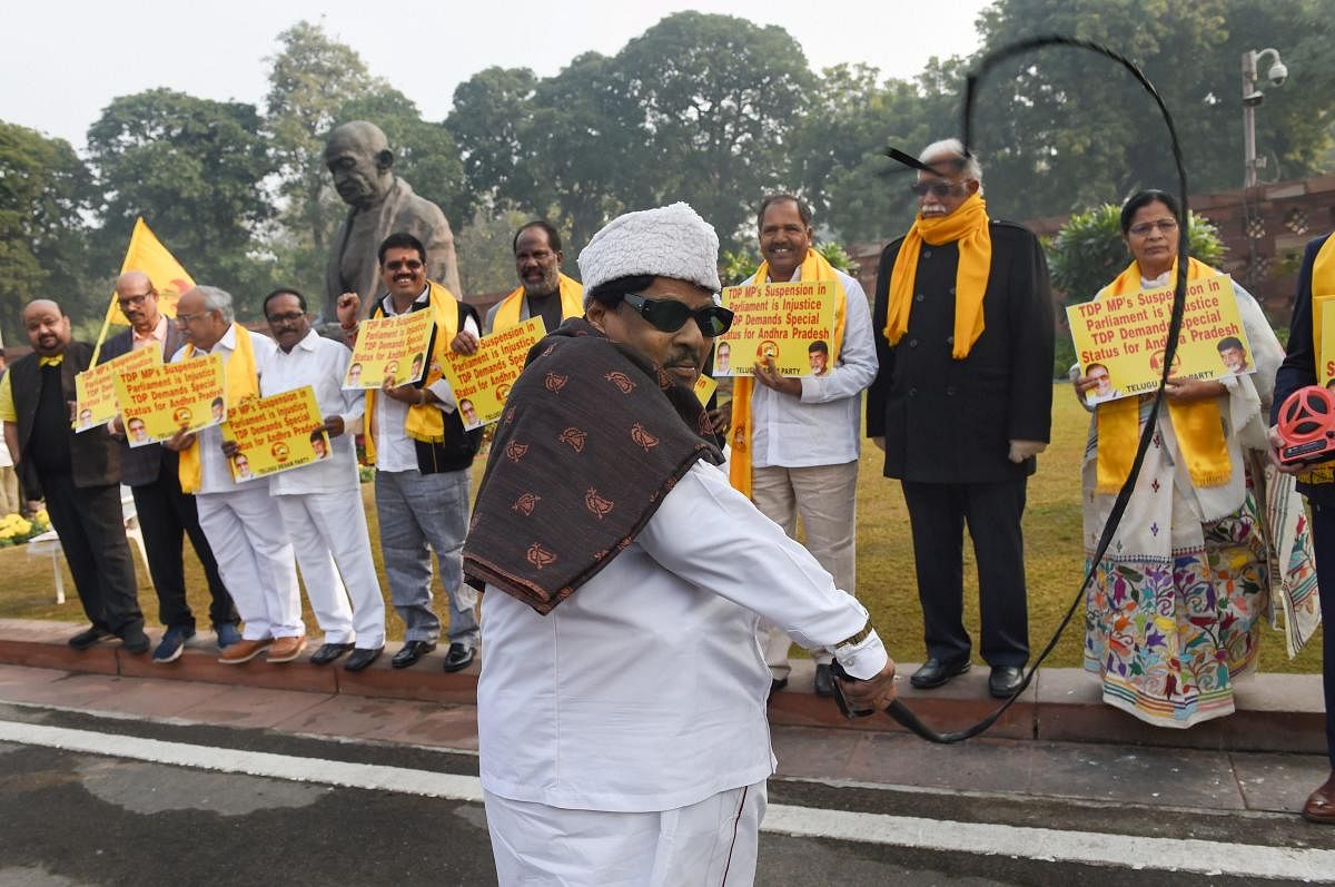 TDP MP Naramalli Sivaprasad with party MPs stage a protest demanding for special package for Andhra Pradesh, during the Winter Session of Parliament, in New Delhi on Monday. (PTI Photo)