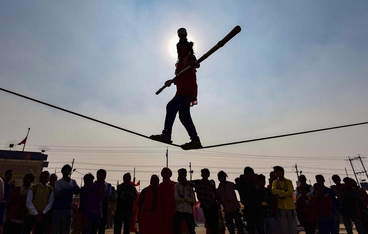 Silhouette of a young girl seen performing stunts as she walks on a tightrope at the Kumbh Mela 2019, in Allahabad. (PTI Photo)