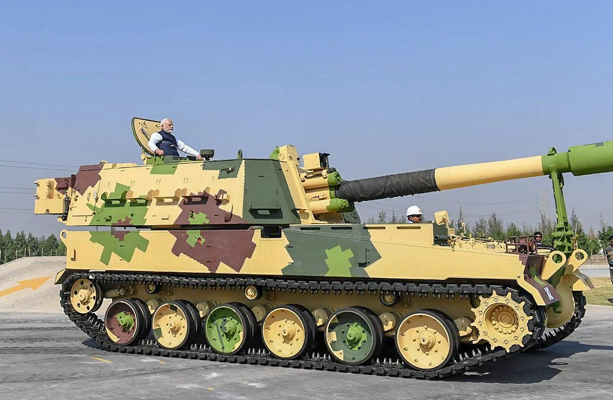 Prime Minister Narendra Modi rides a K-9 Vajra Self Propelled Howitzer built by Larsen & Toubro after the dedication of L&T's Armoured System Complex to the nation, in Hajira. (Twitter Photo via PTI)
