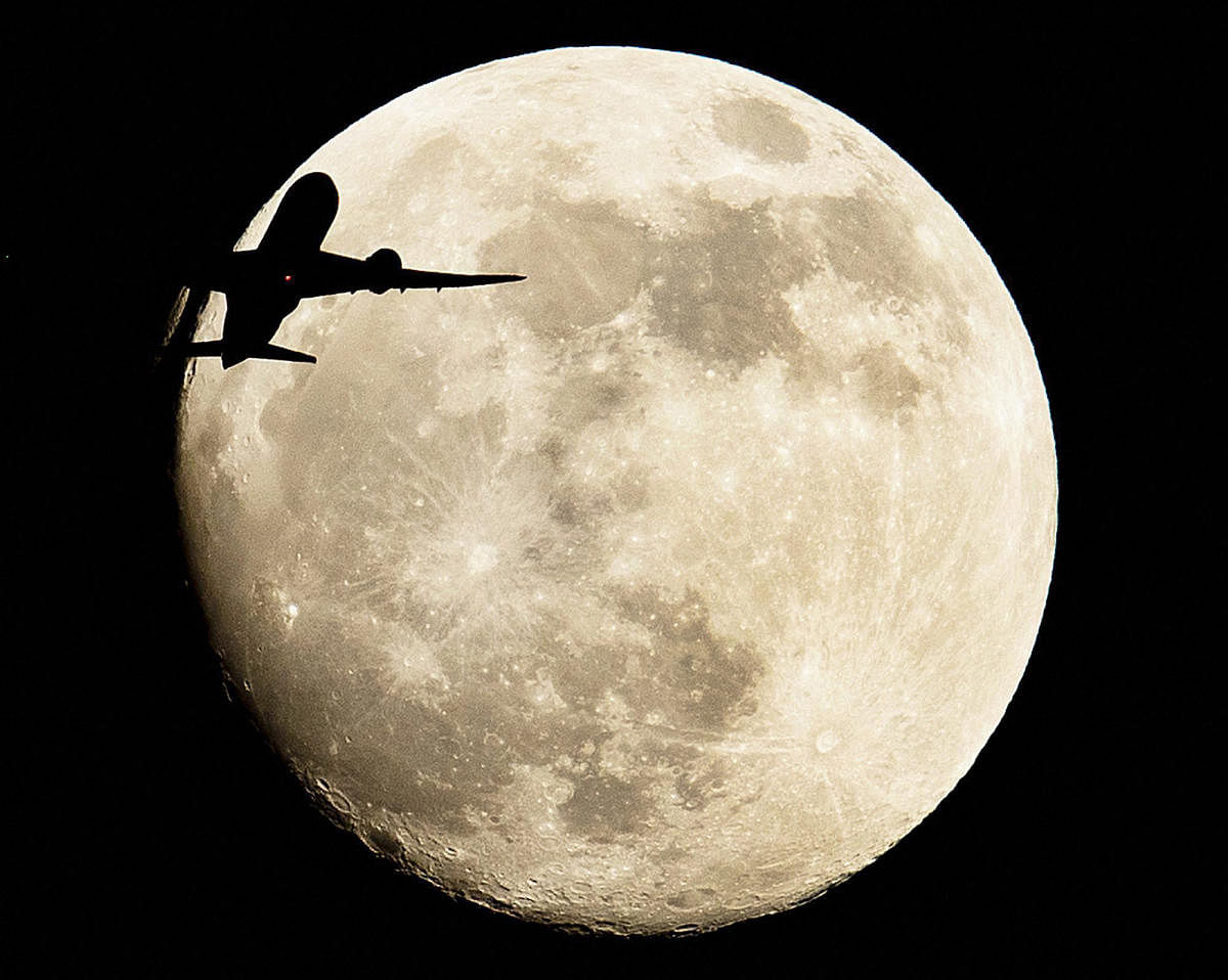 An aircraft passes the moon over Frankfurt, Germany. (AP/PTI Photo)