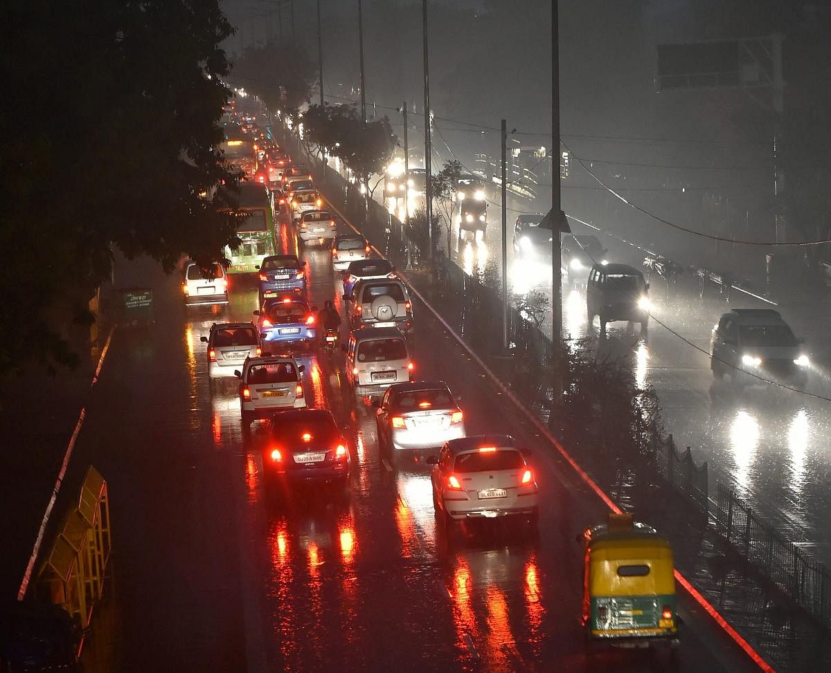 Vehicles ply with their headlights on as visibility gets poor at 08:11 am, during rains in New Delhi. (PTI Photo/Kamal Kishore)
