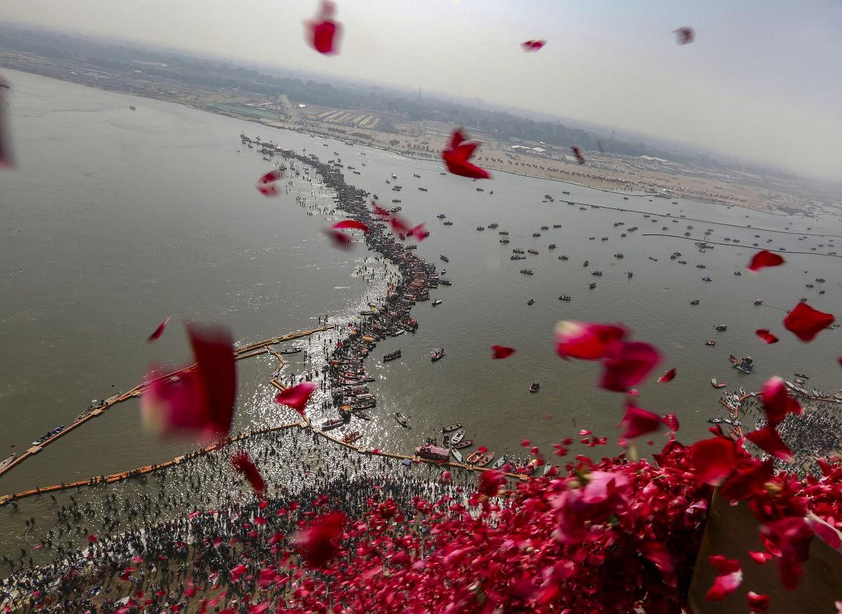 Uttar Pradesh government officials throw rose petals from a helicopter on devotees taking ritualistic dips at Sangam, on 'Paush Purnima' during Kumbh Mela or Pitcher festival, in Allahabad. (PTI Photo)
