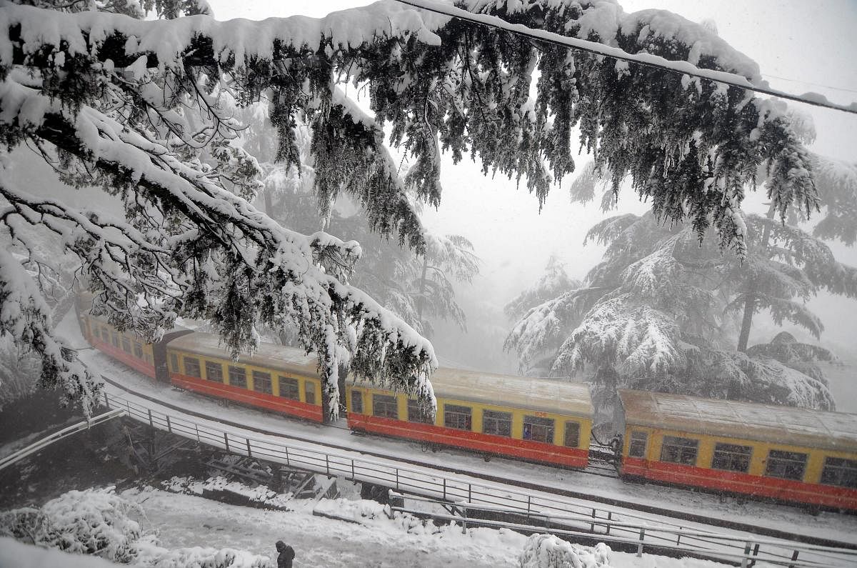 The toy train runs on Kalka-Shimla heritage rail track during heavy snowfall in northern hill town of Shimla. (PTI Photo)