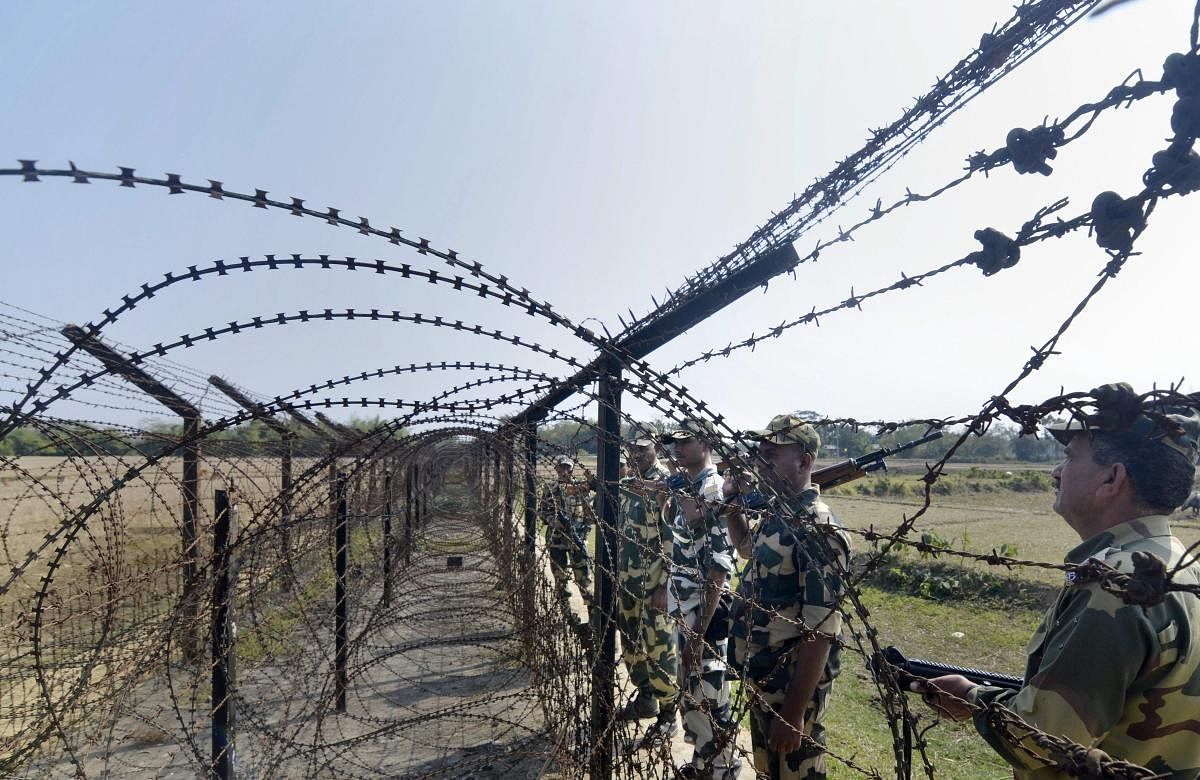 Border Security Force (BSF) personnel patrol along the India- Bangladesh border fencing ahead of the 70th Republic Day function, at Ragna village in Dharmanagar. (PTI Photo)