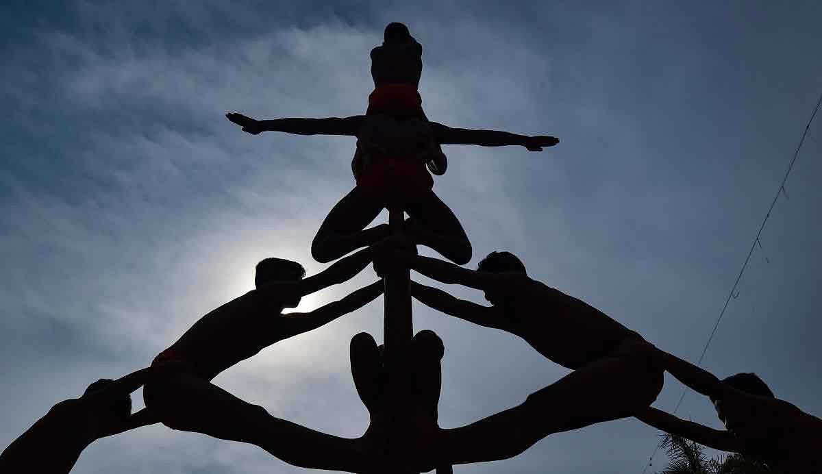 A silhouette of boys seen against the evening sky, performing Malkhamb at Shayona Study Camps ground organised by Gujarat State Malkhamb Association, in Ahmedabad, Thursday, Jan 31, 2019. (PTI Photo)