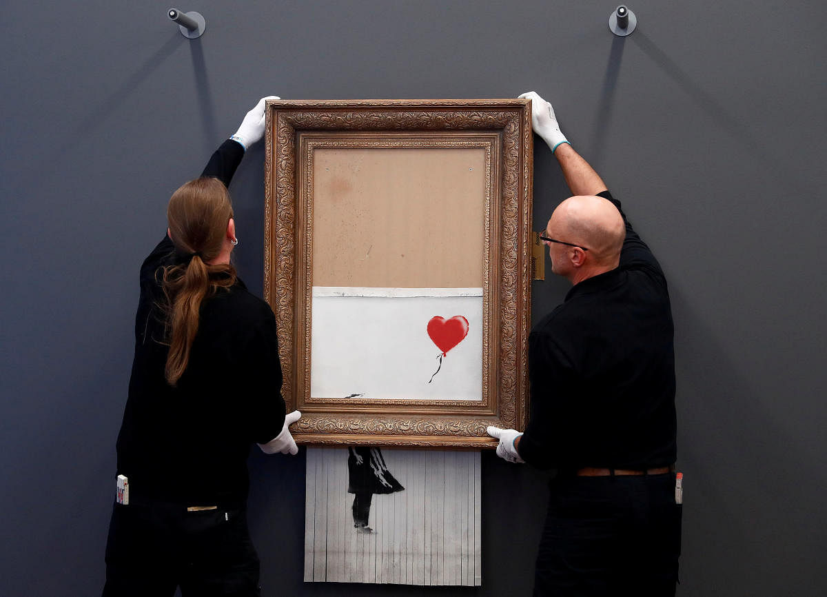 Employees of the Frieden Burda museum put Banksy's partially shredded artwork