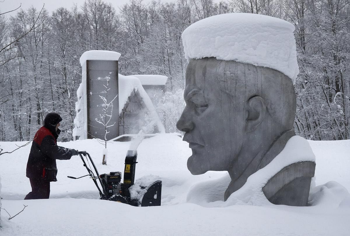 St.Petersburg: A worker clears snow next to the snow covered statue of Soviet Union founder Vladimir Lenin at the Lenin Hut Museum in a forest near Razliv Lake, outside St. Petersburg, Russia, Monday, Feb. 4, 2019. Another cyclone caused a week of snowfall in St. Petersburg. AP/PTI