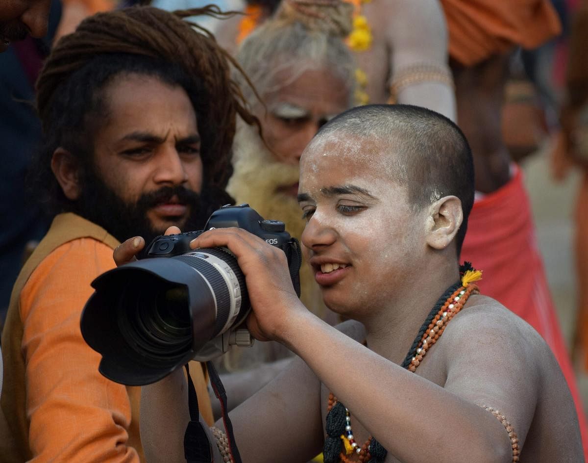 Allahabad: Sadhus shoot on a DSLR camera on a bank of Ganga river during the ongoing Kumbh Mela festival, in Allahabad, Wednesday, Feb 6, 2019. (PTI Photo)