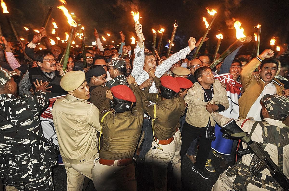 Asom Gana Parishad members clash with police personnel during their torchlight vigil in protest against Citizenship Amendment Bill, in Guwahati, Friday, Feb 8, 2019. (PTI Photo)