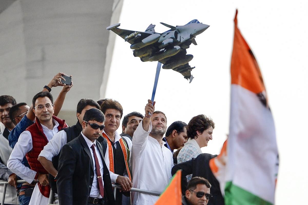 Congress President Rahul Gandhi holds a model of Rafale aircraft during a roadshow along with the party general secretaries Priyanka Gandhi Vadra and Jyotiraditya Scindia, in Lucknow, Monday, Feb. 11, 2019. (PTI Photo)
