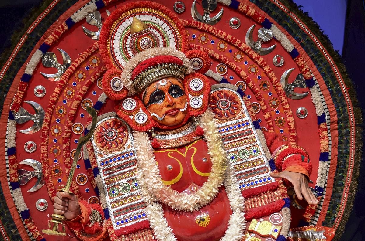 A Theyyam artist poses for photographs before a performance, during a press conference of Kerala Tourism, in Bengaluru, Tuesday, Feb 12, 2019. (PTI Photo/Shailendra Bhojak)