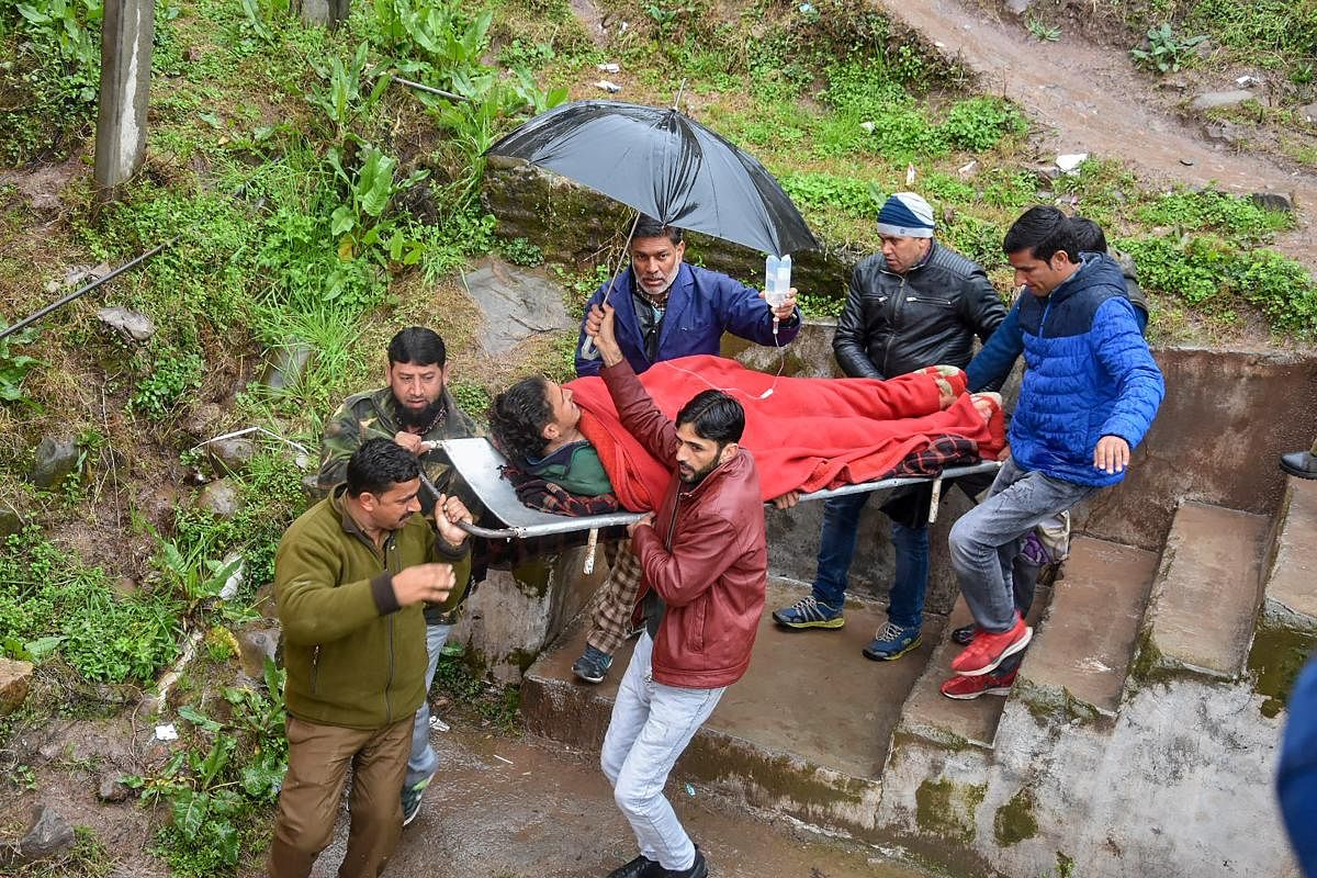People carry an injured person, after he was wounded due to a shell that was allegedly fired by Pakistan troops along the Line of Control (LoC), in Jammu. PTI