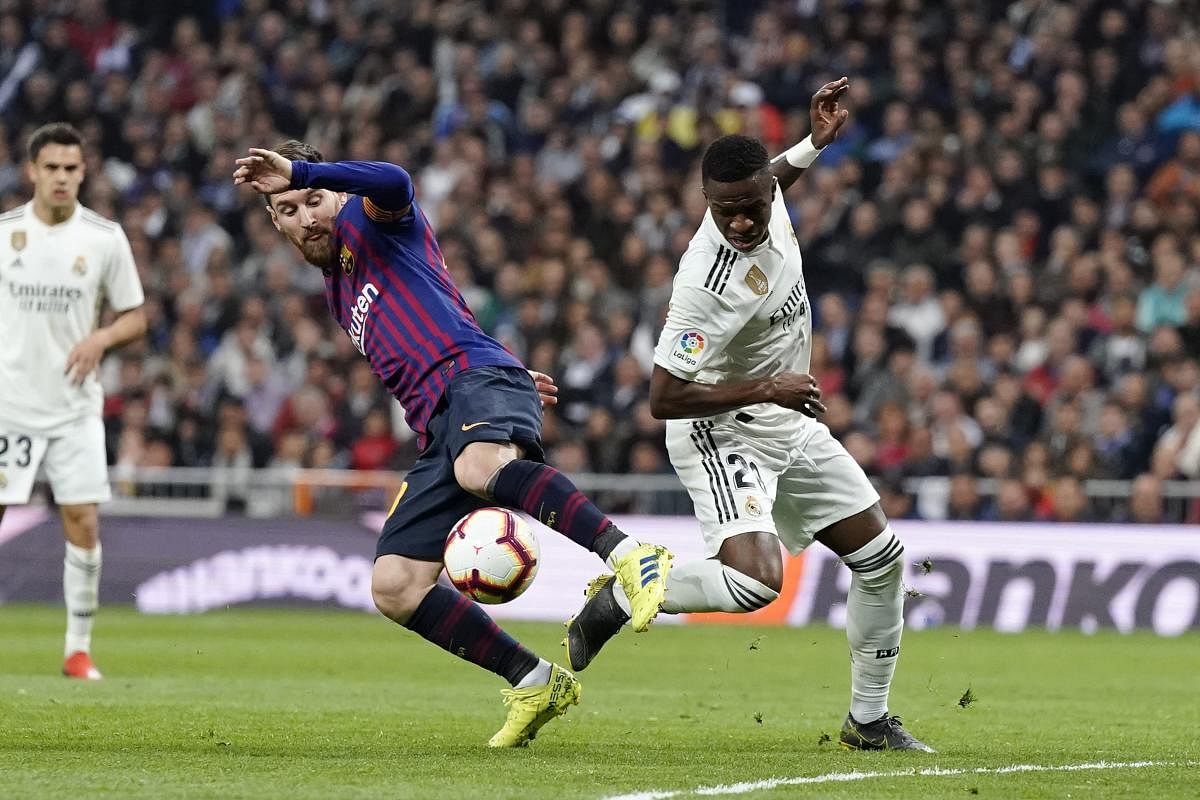 Barcelona forward Lionel Messi, left, and Real forward Vinicius Junior fight for the ball during the Spanish La Liga soccer match between Real Madrid and FC Barcelona at the Bernabeu stadium in Madrid. AP/PTI
