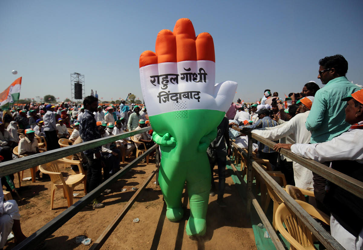 A supporter wearing an inflatable symbol of India's main opposition Congress party walks during a public meeting in Gandhinagar, Gujarat, India, March 12, 2019. The words read: