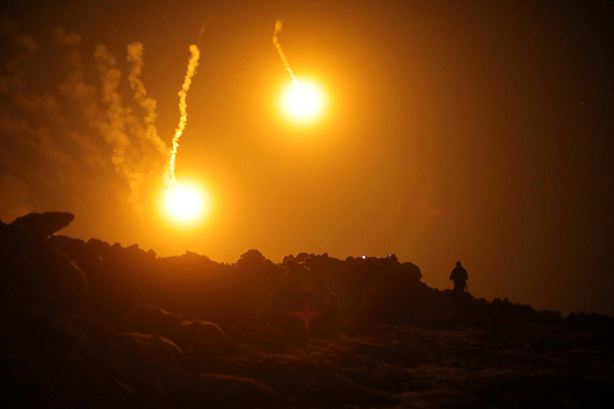 Flares are seen in the sky during fighting in the Islamic State's final enclave, in the village of Baghouz, Deir Al Zor province, Syria March 11, 2019. REUTERS/Rodi Said
