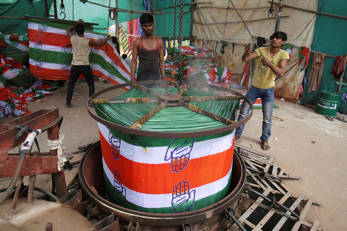 A worker pulls out a roll of cloth from a boiler after dyeing it with the symbol of India's main opposition Congress party at a flag manufacturing factory, ahead of the 2019 general elections, in Ahmedabad, India, March 13, 2019. REUTERS/Amit Dave