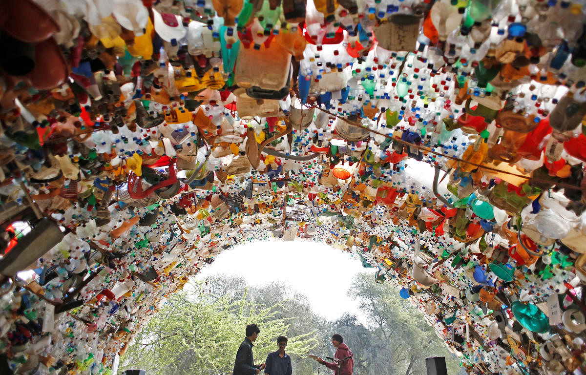 Students perform under a shade made from used plastic bottles as they take part in a global protest against climate change in Gurugram. (Reuters Photo)
