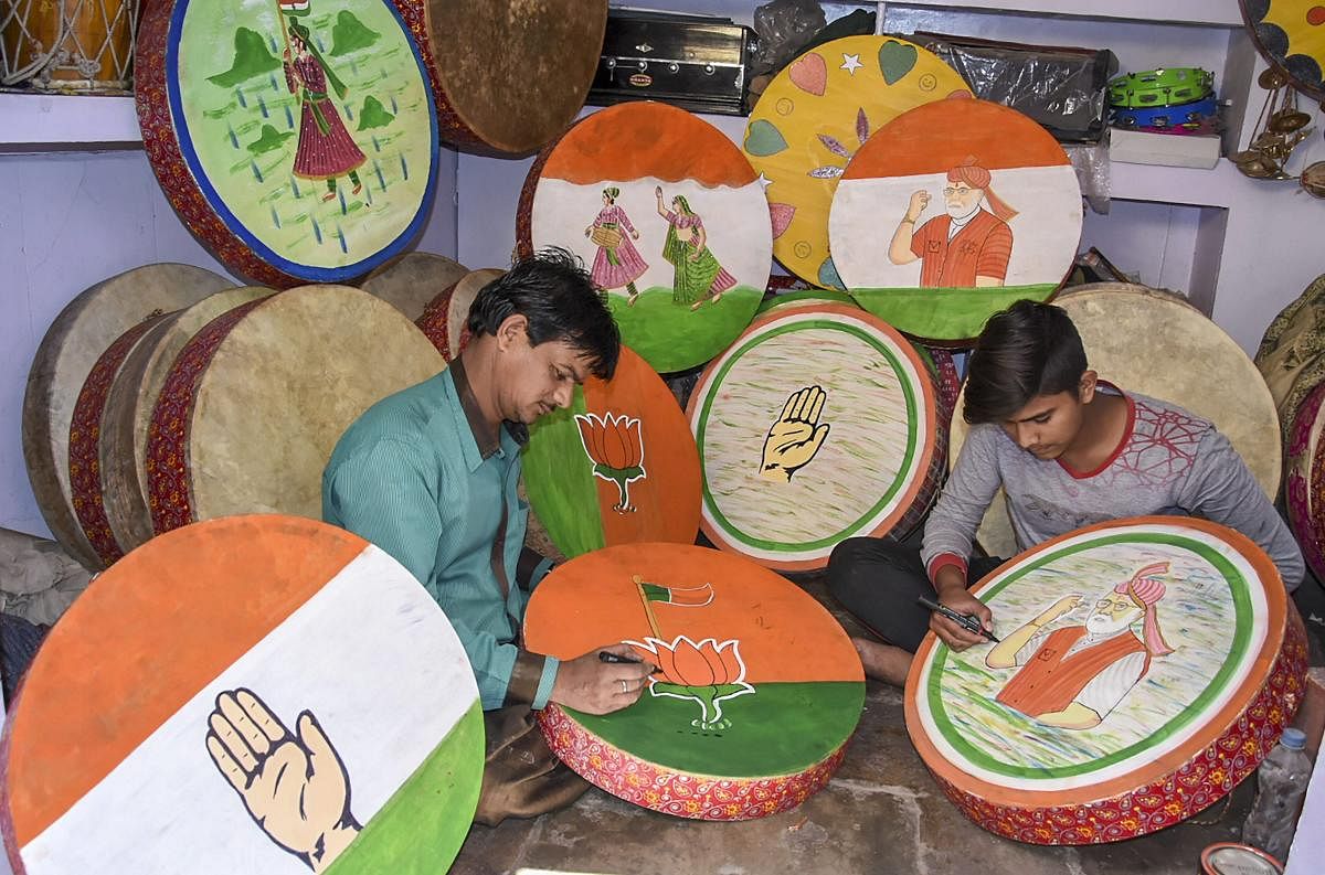 Artisans paint drums with party symbols ahead of Lok Sabha election 2019 in Jodhpur. (PTI Photo)