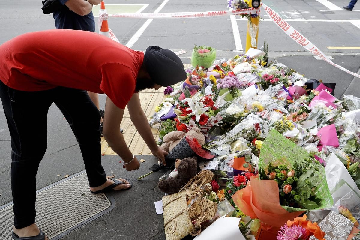 A man places flowers at a makeshift memorial near the Masjid Al Noor mosque in Christchurch, New Zealand, where one of the two mass shootings occurred. (AP/PTI Photo)