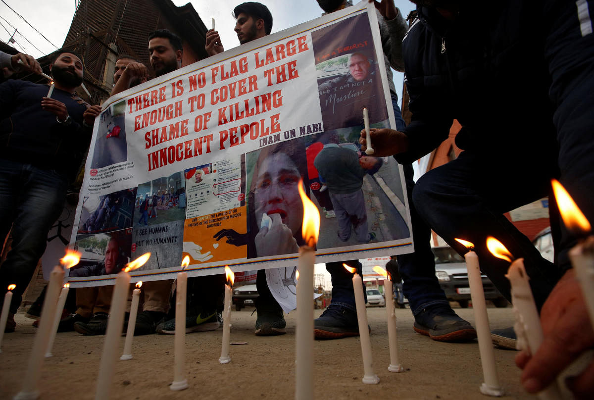 People light candles as they hold a banner during a protest against Friday's mosque attacks in New Zealand, in Srinagar. (Reuters Photo)