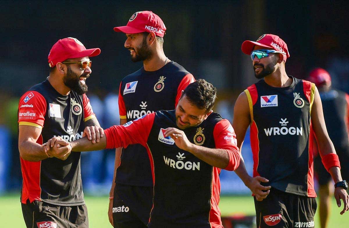 Royal Challengers Bangalore's Skipper Virat Kohli with teammate Parthiv Patel and others share a lighter moment during their training session ahead of the Indian Premier League 2019 (IPL T20) cricket match between Royal Challengers Bangalore (RCB) and Mumbai Indians (MI), at Chinnaswamy Stadium in Bengaluru, Wednesday, March 27, 2019. (PTI Photo)