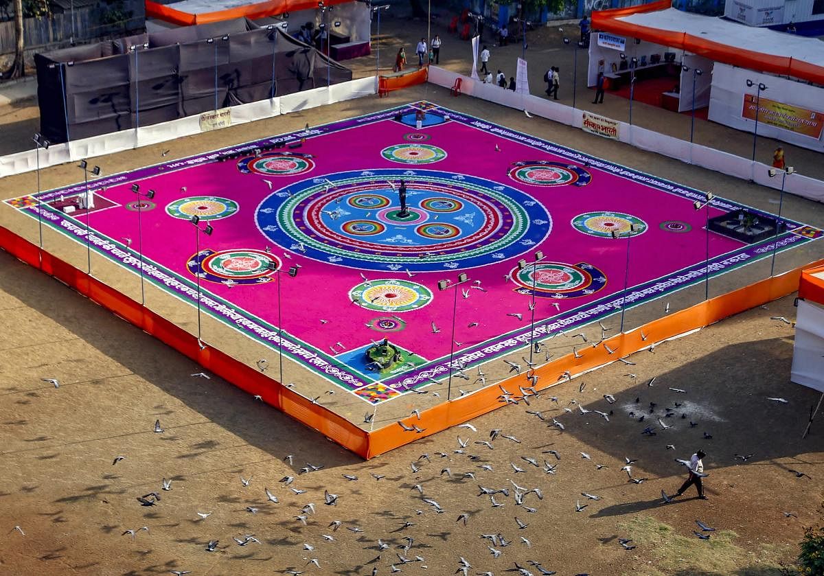 Artists create a 16,000 sq ft 'rangoli' at Gaondevi ground ahead of Gudi Padwa festival, in Thane, Friday, April 05, 2019. (PTI Photo)