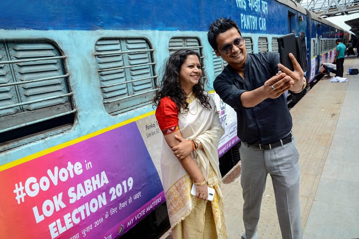 Actor Kopil Bora and singer Tarali Sarma take selfie near the Guwahati-Okha Dwarka Express which is branded with systematic voters education and electoral participation messages for the Lok Sabha polls, before it was flagged off at Guwahati Railway station in Guwahati, Monday, April 8, 2019. (PTI Photo)