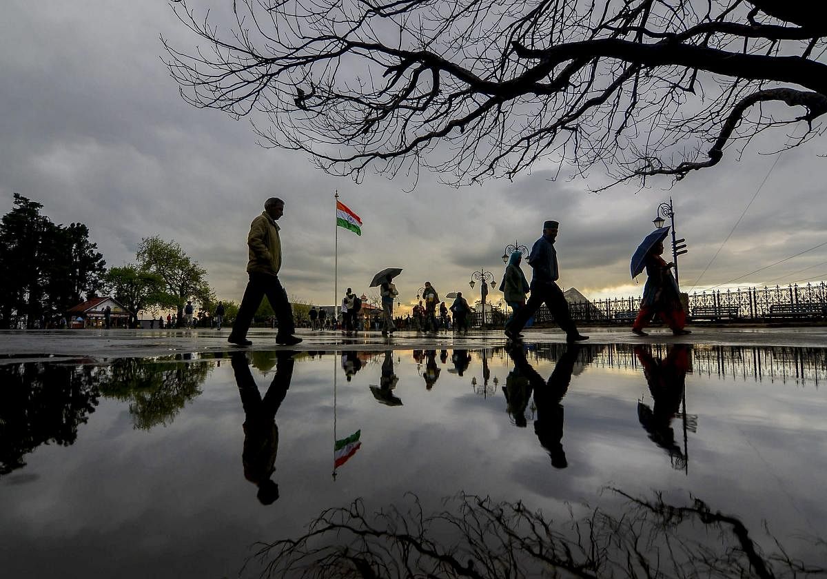 People take a stroll as dark clouds hover in the sky, in Shimla, Monday, April 08, 2018. (PTI Photo)