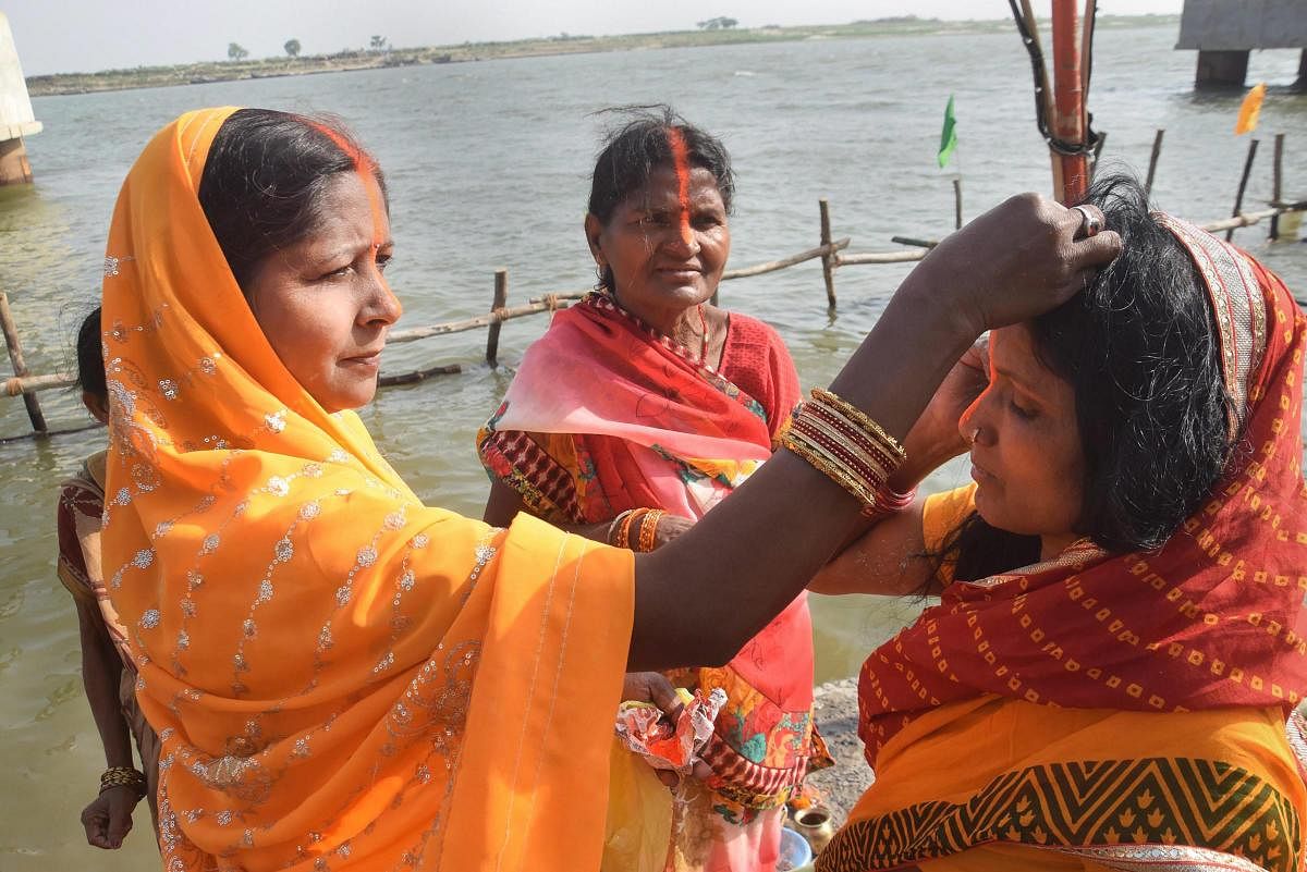 Devotees perform rituals as they offer prayers to the rising sun on the banks of River Ganga during the ‘Chaiti Chhath Puja’, in Patna, Wednesday, April 10, 2019. (PTI Photo)