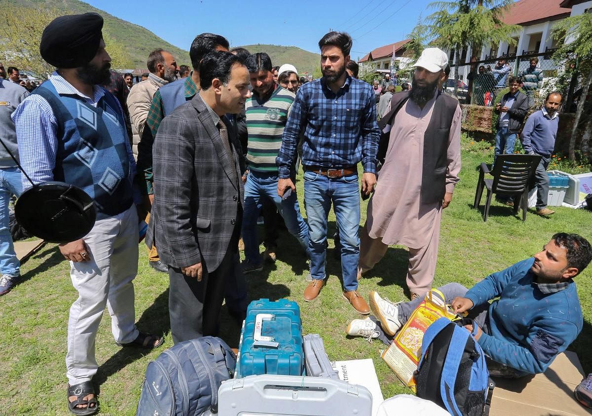 Election officials collect EVMs and and other material for the first phase of Lok Sabha elections, at a distribution centre in Barmamulla district of north Kashmir, April, 10, 2019. (PTI Photo)