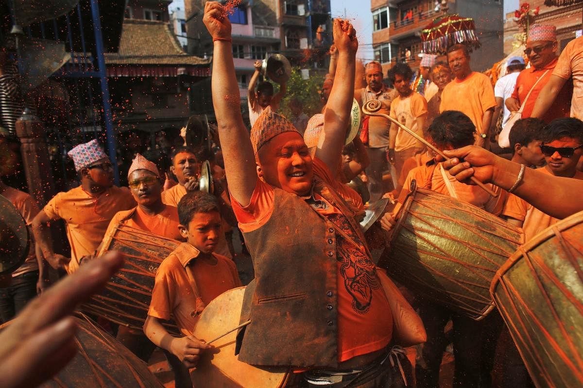 A Nepalese man covered in vermillion powder or Sindoor dances during Sindoor Jatra festival in Bhaktapur, Nepal, Monday, April 15, 2019. Devotees mark the festival by playing traditional drums, singing, dancing and carrying chariot of various deities around town while throwing vermillion powder to welcome the advent of spring and the New Year