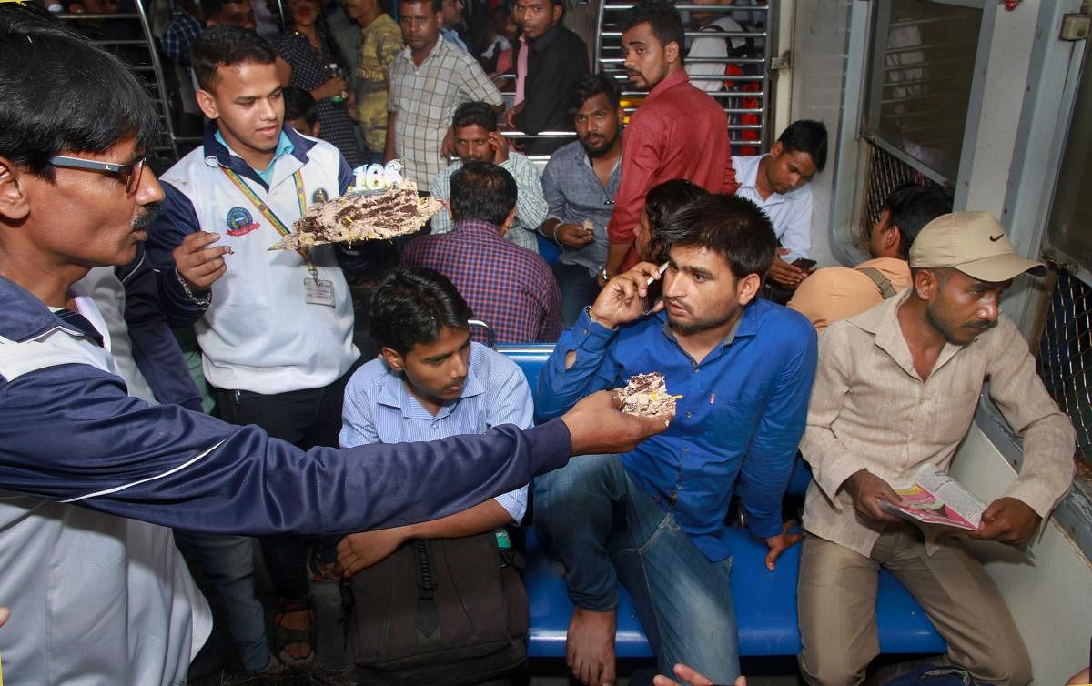Railway employees offer cake to commuters as they commemorate the 166th year of Indian Railways, in Thane, Tuesday, April 16, 2019. On April 16, 1853, the first passenger train of Indian Railways ran between Bori Bunder (Mumbai CSMT) and Thane. PTI