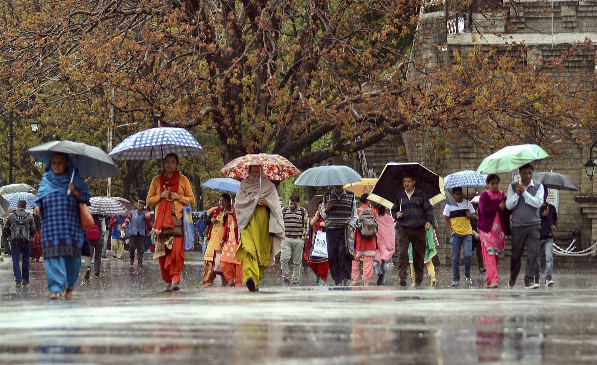 Pedestrians carry umbrellas during rain, in Shimla, Tuesday, April 16, 2019. PTI