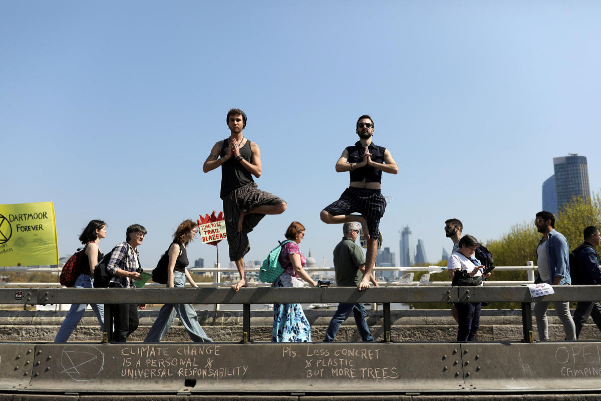 Climate change activists practice yoga on Waterloo Bridge during the Extinction Rebellion protest in London, Britain April 20, 2019. REUTERS/Simon Dawson