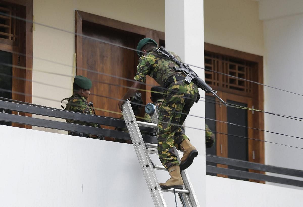 A Sri Lankan police commando enters a house suspected to be a hideout of militants following a shoot out in Colombo, Sri Lanka, Sunday, April 21, 2019. More than hundred were killed and hundreds more hospitalized with injuries from eight blasts that rocked churches and hotels in and just outside of Sri Lanka's capital on Easter Sunday, officials said, the worst violence to hit the South Asian country since its civil war ended a decade ago. AP/PTI