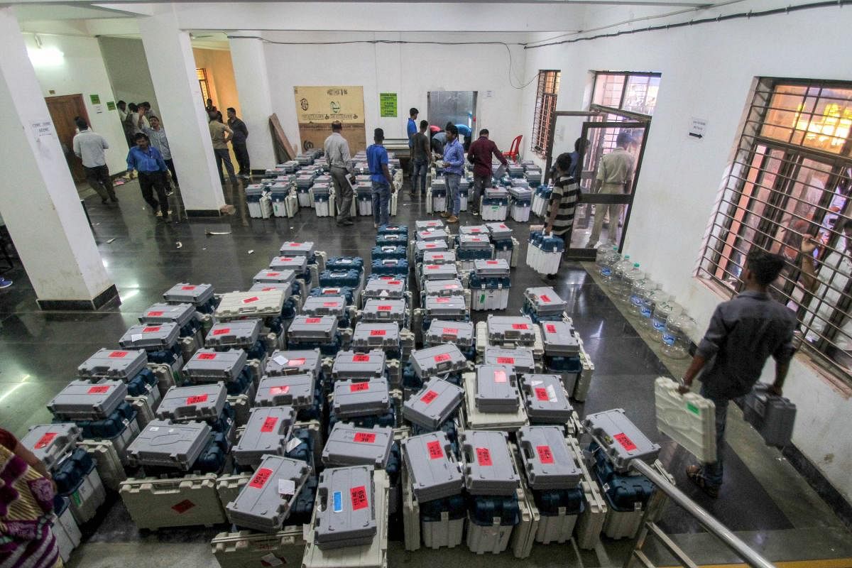 Election staff inspect the boxes containing EVMs and other election material ahead of the third phase of the 2019 Lok Sabha elections, at a distribution centre, in Bhubaneswar, Sunday, April 21, 2019. (PTI Photo)