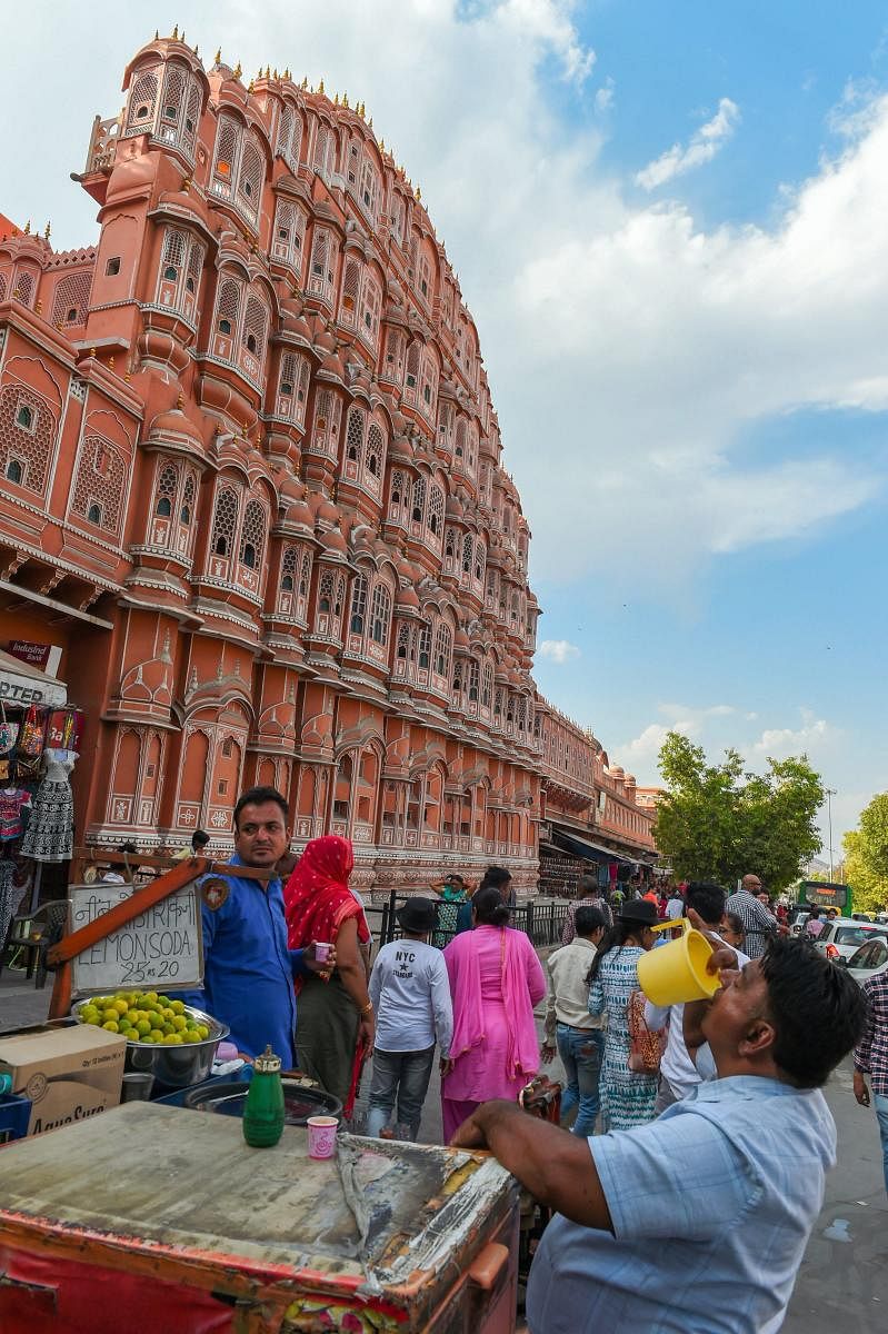 A man quenches his thirst on a hot summer day out the Hawa Mahal, in Jaipur, Sunday, April 21, 2019. (PTI Photo/Shahbaz Khan)