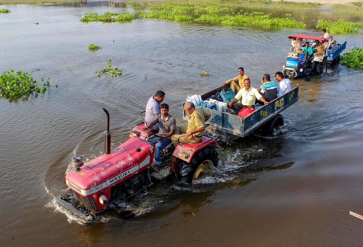 Election officials along with security personnel travel by tractors to reach a polling station, at Hajo in Kamrup district of Assam, Monday, Apr 22, 2019. (PTI Photo)