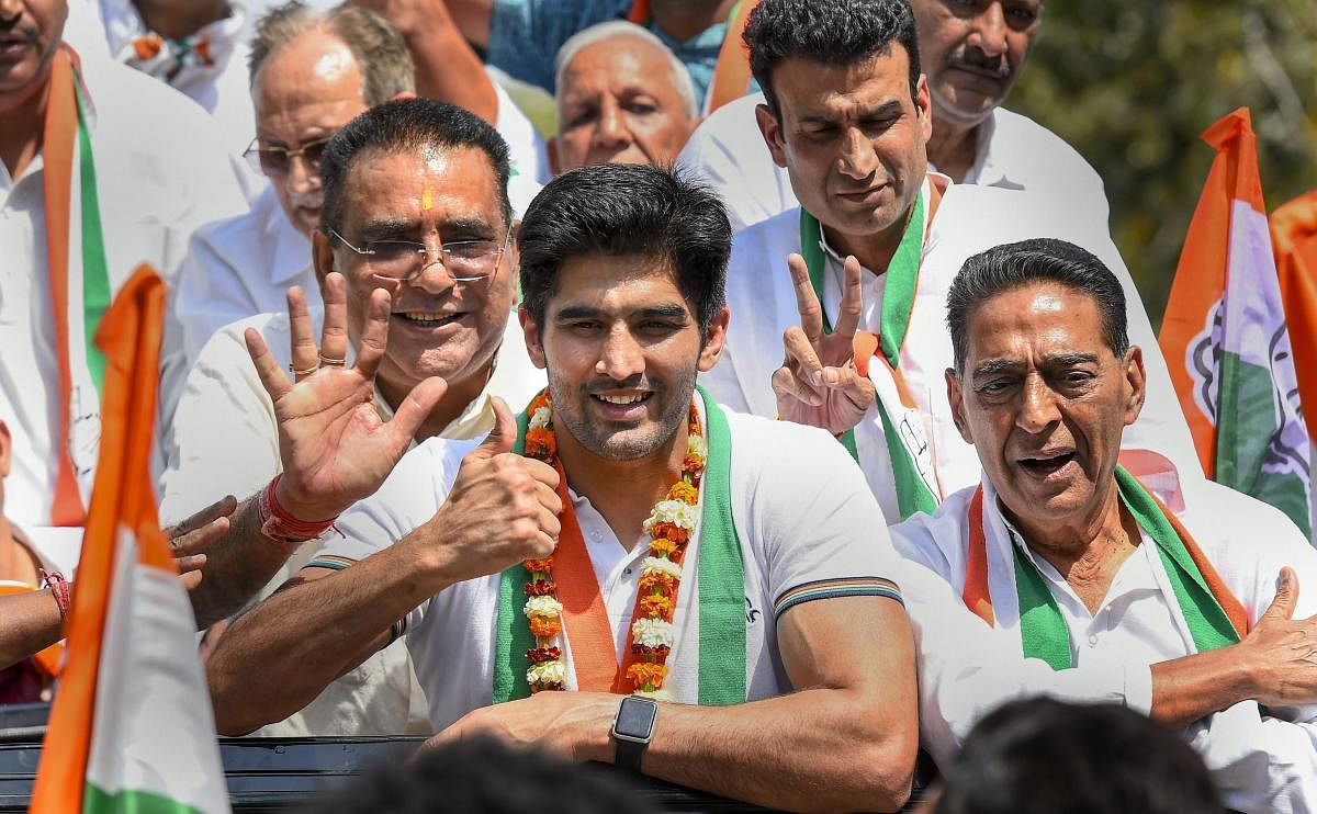 Boxer and Congress candidate from South Delhi constituency Vijender Singh flashes the victory sign during his nomination filing procession for the Lok Sabha polls, in New Delhi, Tuesday, April 23, 2019. (PTI Photo/Kamal Singh)